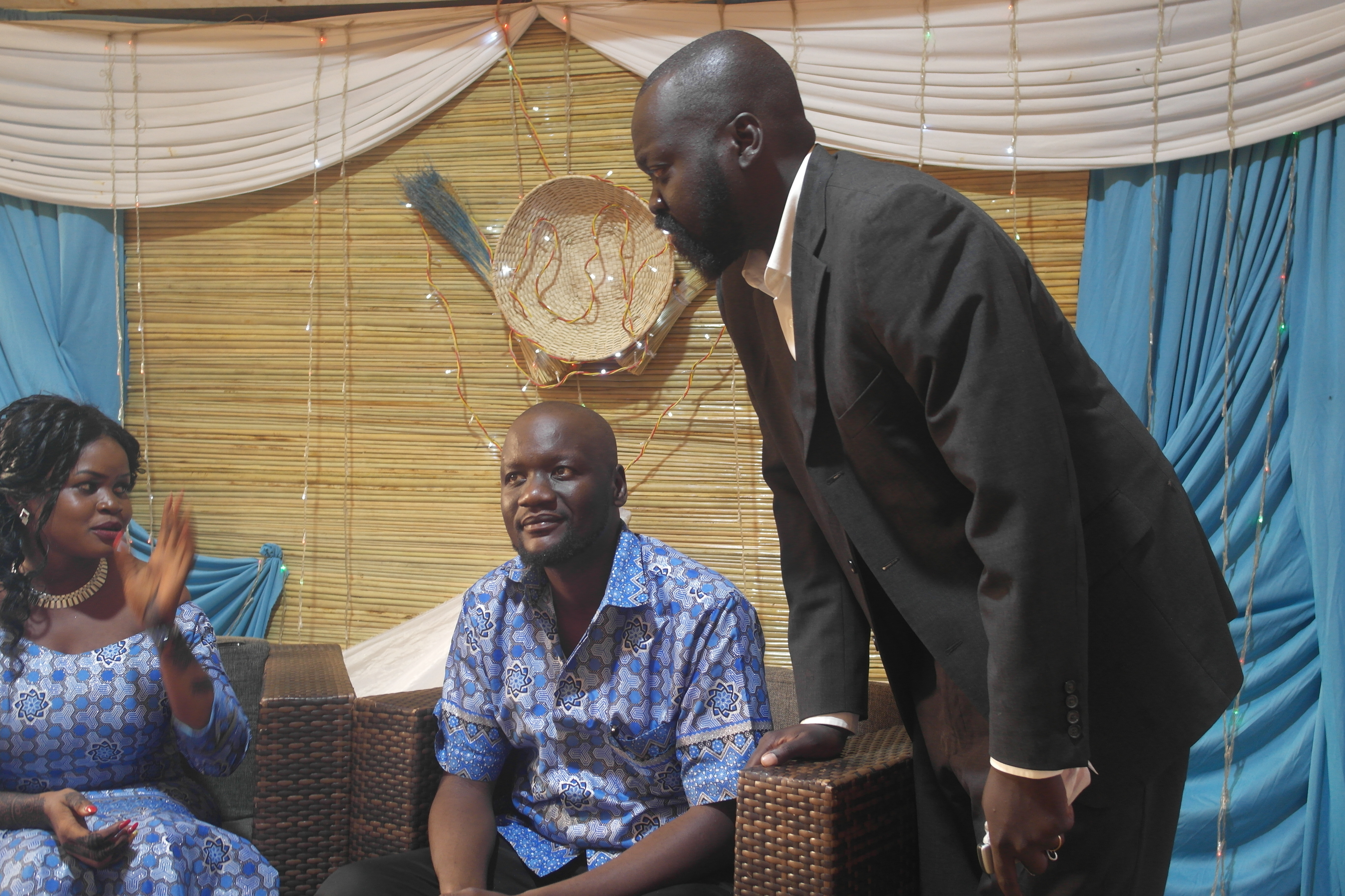 Labana speaking with a seated couple at a celebration