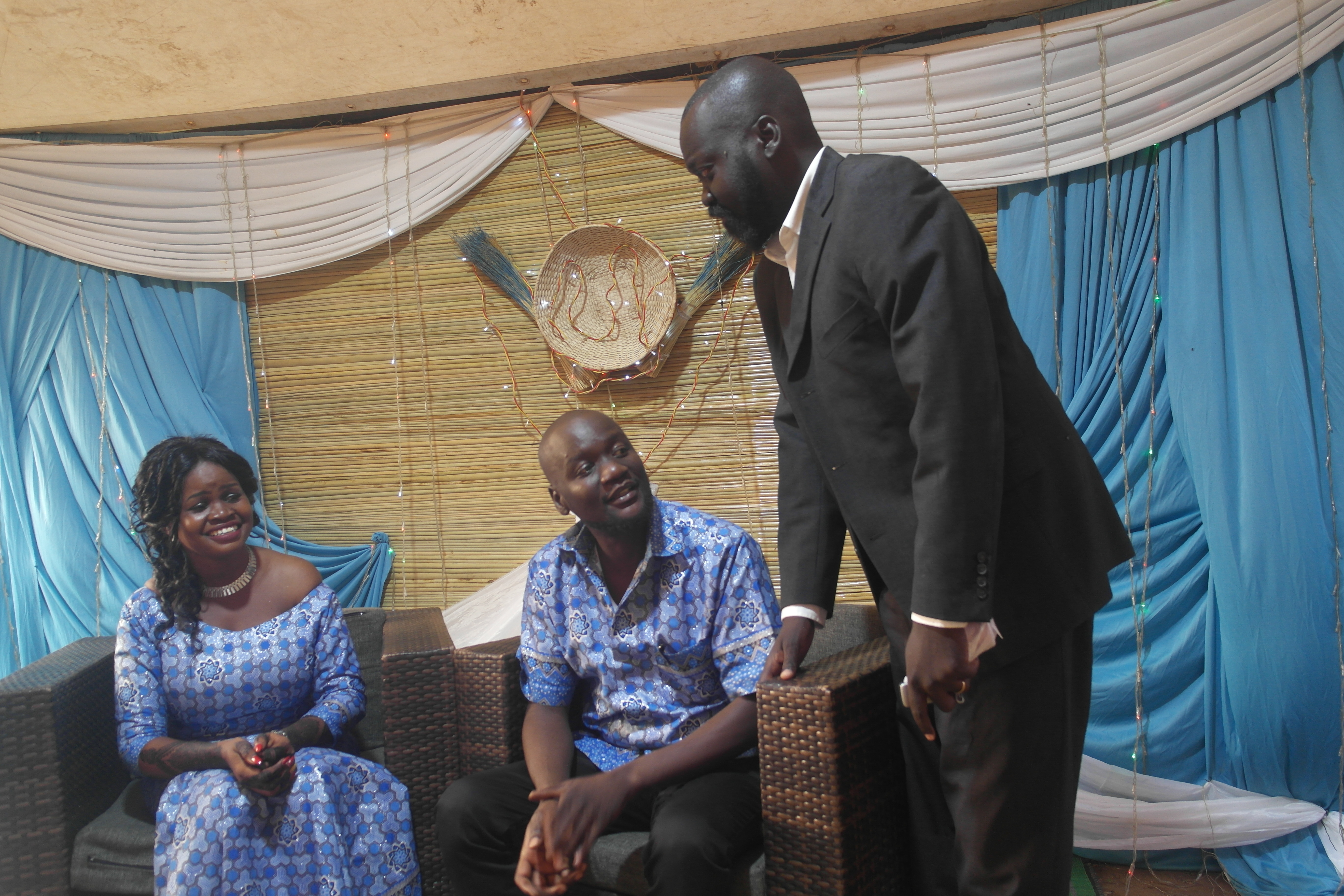 Labana conversing with a seated couple at a celebration